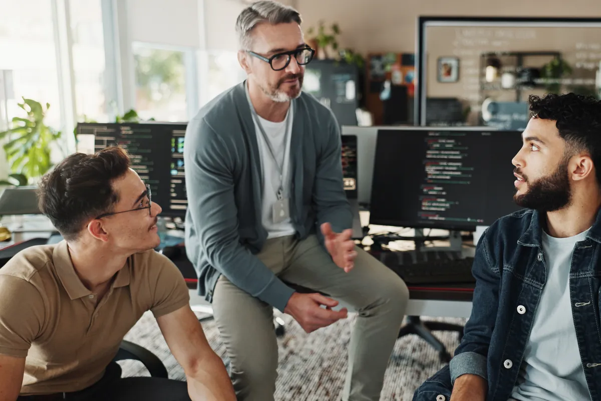 Three people talking through a business problem in an office, the first conversation of a software project